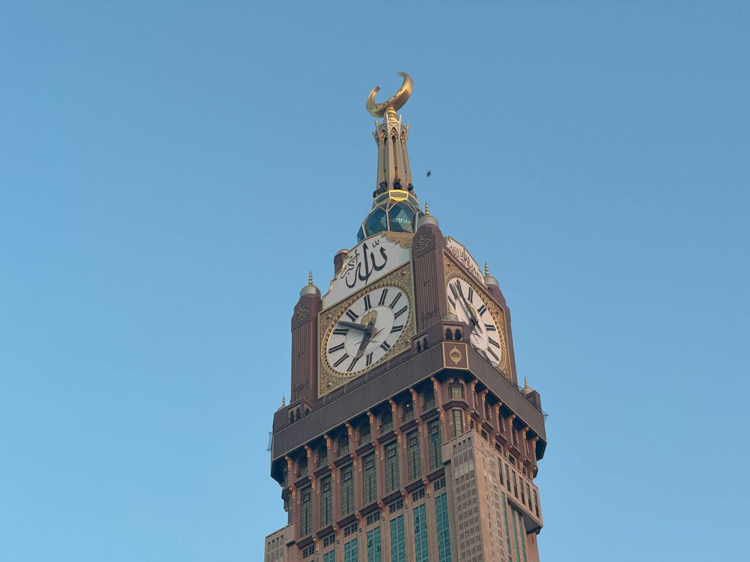 A stunning view of the Clock Tower at Abraj Al Bait, Mecca against a clear blue sky.