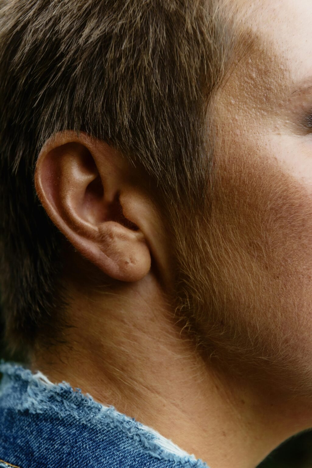 Detailed side profile showcasing a man's ear and short hair.