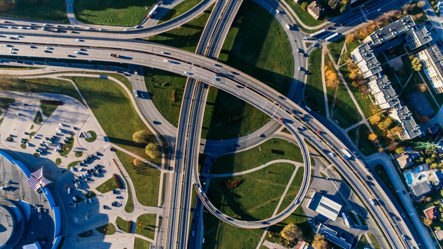 Aerial photograph of a complex highway interchange, capturing dynamic city traffic.