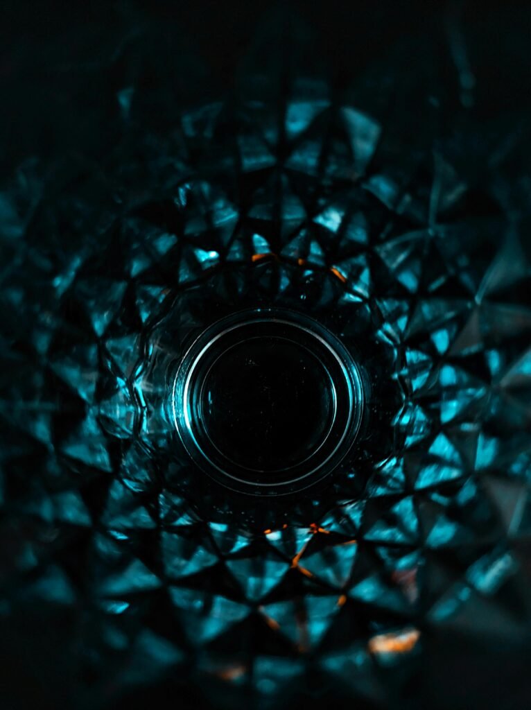 Intricate geometric glass pattern captured with dramatic lighting creating an abstract effect.